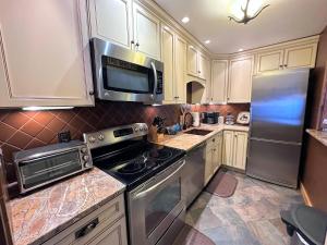 a kitchen with a stove and a microwave at FC17 Stylishly renovated Forest Cottage walk to Bretton Woods ski trails wifi cable ping pong in Carroll