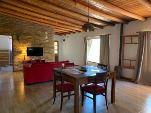 a living room with a table and chairs and a couch at 7 Colores Casas Serranas in San Marcos Sierras
