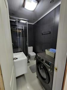 uma casa de banho com um WC e uma máquina de lavar roupa em Cabañas Pewmawapi em Quellón