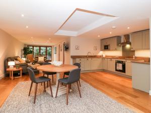 a kitchen and living room with a table and chairs at Olive Tree Cottage in Langport