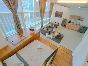 een woonkamer en eetkamer met grote ramen bij Empire City PJ Signature Suites by Manhattan Group in Petaling Jaya