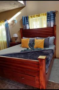 Un dormitorio con una gran cama de madera con almohadas amarillas. en Cambridge mi casa ur casa with pool and beach access, en Runaway Bay