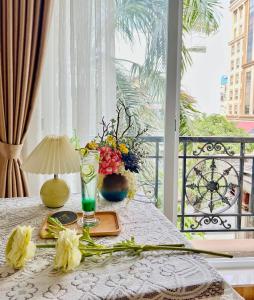 a table with flowers and a lamp on a balcony at Air Star Hotel in Ho Chi Minh City