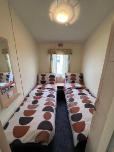 um pequeno quarto com duas camas no canto em 3 Bedroom 8 Berth cosy static family caravan em Rhyl