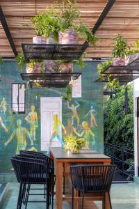 a patio with a table and chairs and a wall with a painting at Roso Guest House in Mexico City