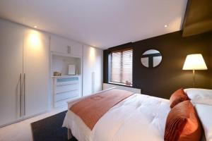 a bedroom with a large bed and a mirror at MR2 - Fantastic 1 Bed apartment Munster Village in London