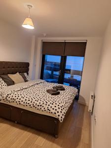 a bedroom with a large bed and a large window at Amazing apartment moments away from the heart of London in London