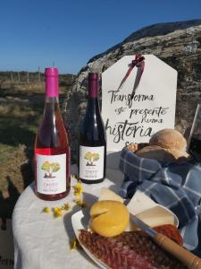 two bottles of wine and cheese on a table at HERDADE DO CORVAL in Reguengos de Monsaraz