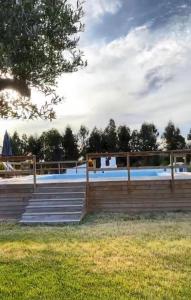 einen Zaun um einen Pool mit einer Holzterrasse in der Unterkunft HERDADE DO CORVAL in Reguengos de Monsaraz
