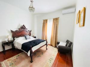 a bedroom with a large bed and a chair at HERDADE DO CORVAL in Reguengos de Monsaraz