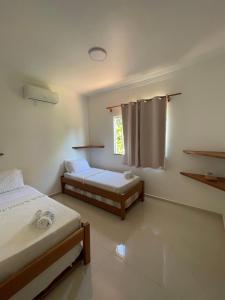 a bedroom with two beds and a window at P&M'S Porto Seguro Taperapuan in Porto Seguro