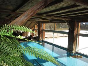 einen Pool in einem Haus mit Glasfenstern in der Unterkunft Studio Etrier 629 in Crans-Montana
