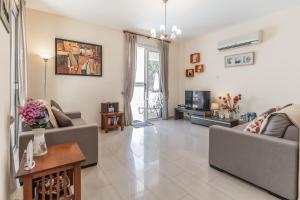 a living room with two couches and a tv at Villa Joia in Ayia Napa
