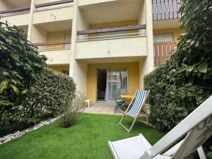 podwórze z dwoma krzesłami i stołem przed budynkiem w obiekcie Studio au calme, plage et centre à pied, jardinet ensoleillé, parking privé - FR-1-550-51 w mieście Saint-Georges-de-Didonne