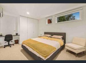 um quarto com uma cama, uma secretária e uma cadeira em Modern South Melbourne Town House. em Melbourne