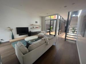 uma sala de estar com um sofá e uma televisão em Modern South Melbourne Town House. em Melbourne