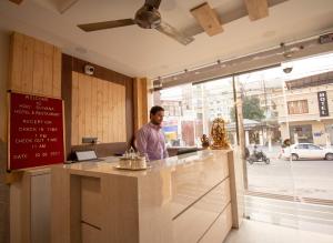 a man standing at a counter in a restaurant at Holy Shivana Boutique Hotel Rishikesh in Rishīkesh