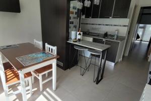 a kitchen with a table and chairs and a counter at Comfortable apartment and excellent location in Ushuaia