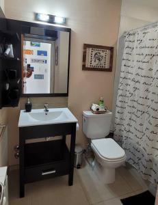 Comfortable apartment and excellent location في أوشوايا: حمام به مرحاض أبيض ومغسلة