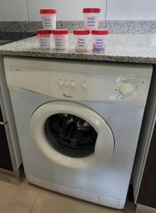 a washing machine with cups on top of it at Comfortable apartment and excellent location in Ushuaia
