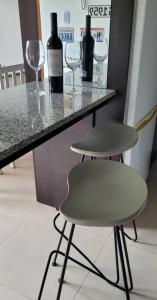 a counter with two bottles of wine and two empty wine glasses at Comfortable apartment and excellent location in Ushuaia