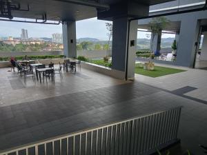 un patio con tavoli e sedie in un edificio di Homestay Juita Vista Bangi a Kajang