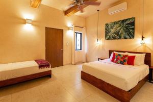 sypialnia z 2 łóżkami w pokoju w obiekcie CASA YAXCHE luxury house in downtown Mérida w mieście Mérida