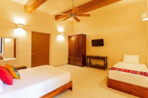a bedroom with two beds and a ceiling fan at CASA YAXCHE luxury house in downtown Mérida in Mérida
