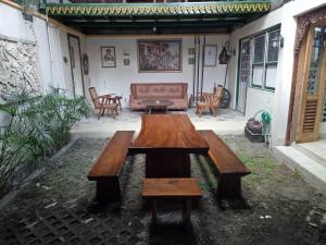 una mesa de madera y un banco en un patio en Omah Ndanu Homestay en Yogyakarta