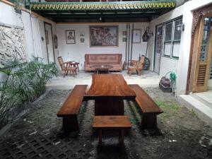 a wooden table and bench on a patio at Omah Ndanu Homestay in Yogyakarta