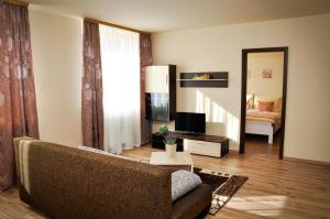 ein Wohnzimmer mit einem Sofa und einem Spiegel in der Unterkunft Apartmany Fonte in Orechová Potôň