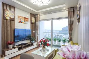 un salon avec une télévision et une grande fenêtre dans l'établissement LiChi Halong Homestay, à Hạ Long