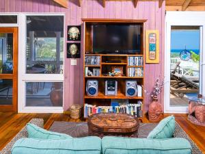 a living room with a tv and a couch and a table at Purple Palace in Sandy Bay