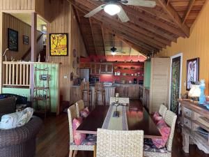 Purple Palace في Sandy Bay: غرفة طعام مع طاولة وكراسي في مطبخ