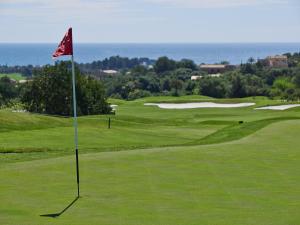 a golf course with a flag on the green at Pula Golf Resort in Son Servera