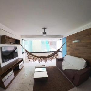 Verão on في كابيديلو: غرفة معيشة مع أريكة ومروحة سقف