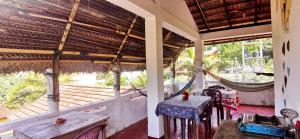 a porch with two tables and a hammock on it at Gunne Fisherman House in Weligama +17 photos