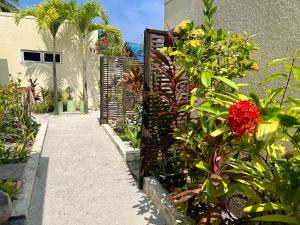 a garden with red flowers and a fence at Athiri Inn Kelaa in Kelaa