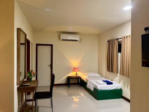 a hotel room with a bed and a desk and a chair at Athiri Inn Kelaa in Kelaa