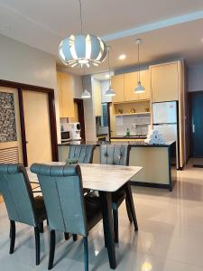 a dining room and kitchen with a wooden table and chairs at Imperial Grand Suite Apartment Kuching in Kuching