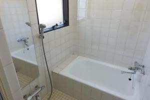 a bathroom with a tub and a shower with a window at Condo within Tokyo DisneyResort 10 people can stay in Tokyo