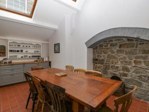 a dining room with a table and a stone fireplace at Kylemore in Glastonbury