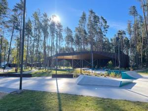 a building in a park with trees in the background at Family Summer House in Jurmala in Jūrmala