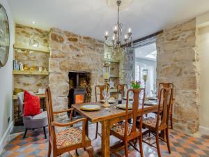 a dining room with a table and chairs and a stone wall at Ivy Mount in Uny Lelant