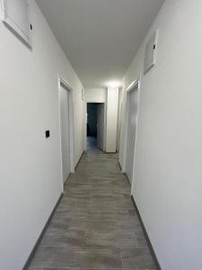 un pasillo vacío con paredes blancas y suelo de baldosa en Rooms Jelak, en Velika Gorica