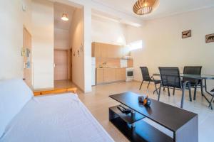 uma sala de estar com uma cama, uma mesa e cadeiras em Veta Apartment - Seaview em PalaiónTsiflíkion
