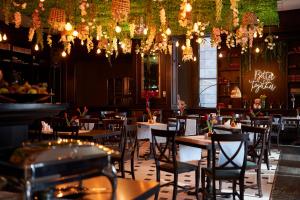 a restaurant with tables and chairs and chandeliers at Central Plaza Hotel in Piatra Neamţ