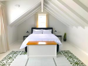 una camera da letto con un letto bianco e una finestra di The Loft on Colenso a Napier