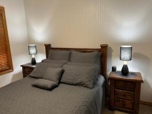 a bedroom with a bed with two lamps on tables at The Kingfisher Lodge 111 in Halls Gap