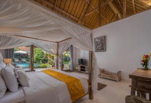 1 dormitorio con 1 cama grande con dosel en The Gardener's Cottage, en Ubud